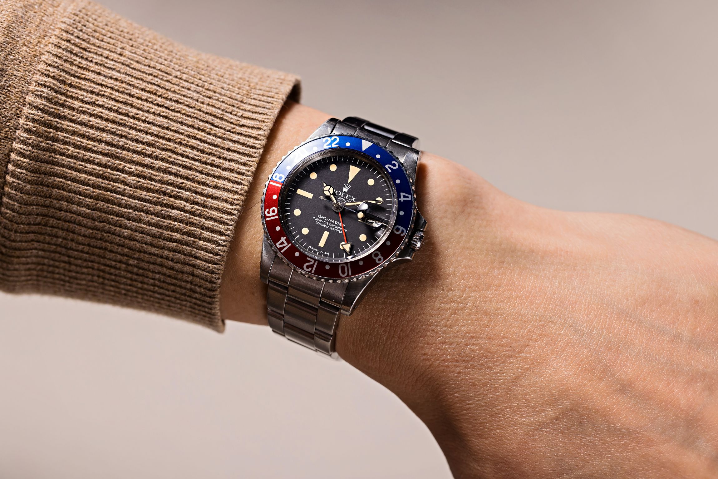 Rolex GMT-Master on a wrist, featuring a black dial with red and blue bezel, reflecting a blend of style and functionality.