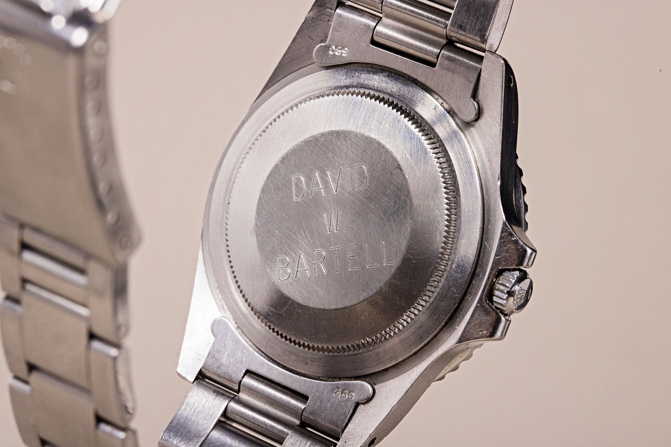 Engravings on the back of a Rolex GMT-Master show "David W. Bartell," highlighting its historical significance.