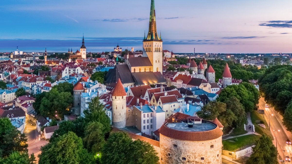 Aerial view of Tallinn's Old Town showcasing medieval architecture and vibrant rooftops against a twilight sky.