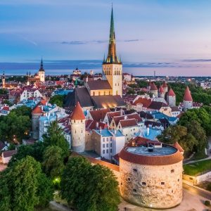 Aerial view of Tallinn's Old Town showcasing medieval architecture and vibrant rooftops against a twilight sky.