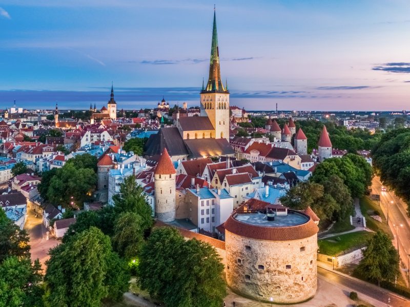 Aerial view of Tallinn's Old Town showcasing medieval architecture and vibrant rooftops against a twilight sky.