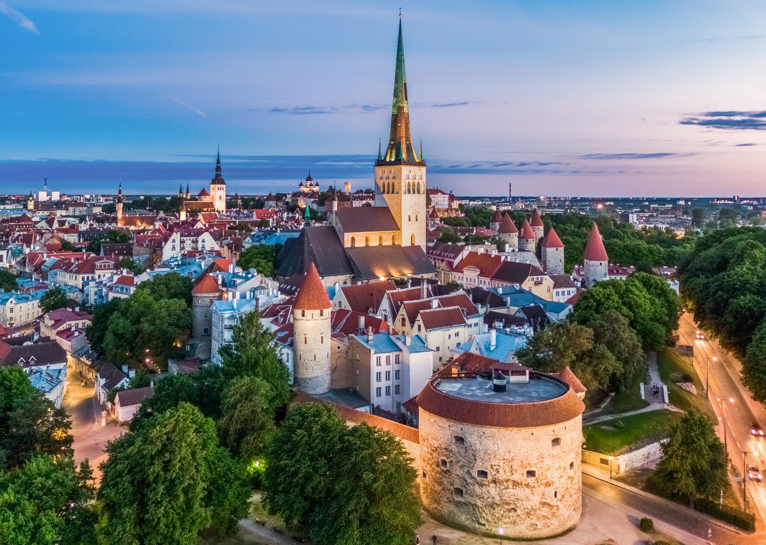Aerial view of Tallinn's Old Town showcasing medieval architecture and vibrant rooftops against a twilight sky.