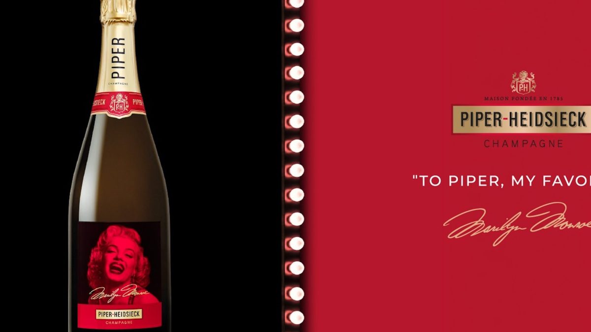 Piper-Heidsieck champagne bottle featuring a Marilyn Monroe design with the text "To Piper, my favorite" on a red backdrop.