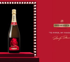 Piper-Heidsieck champagne bottle featuring a Marilyn Monroe design with the text "To Piper, my favorite" on a red backdrop.