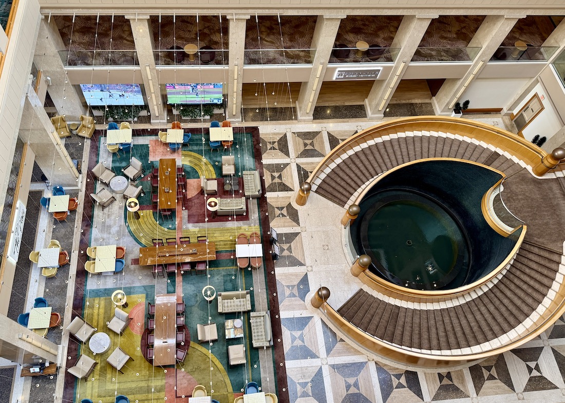 Lobby area of Renaissance Esmeralda Resort featuring colorful seating, tables, and a spiral staircase leading to a water feature.