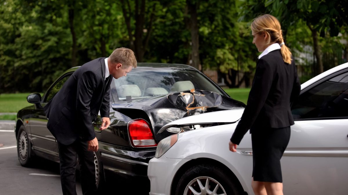 Two professionals assess damage after a car accident, highlighting the importance of smart financial steps post-incident.