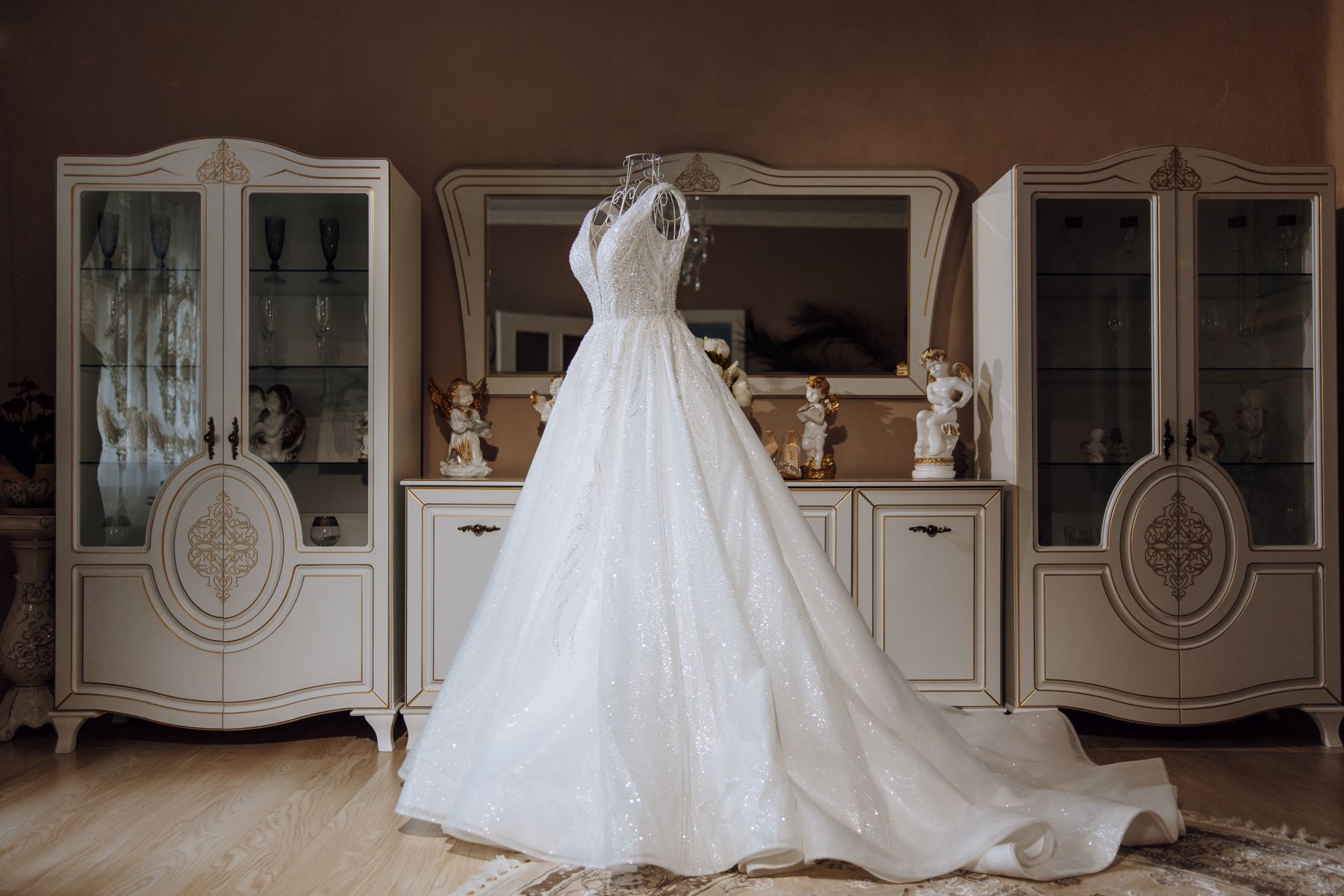 Luxury wedding dress featuring intricate detailing and a flowing train, displayed against an elegant background.