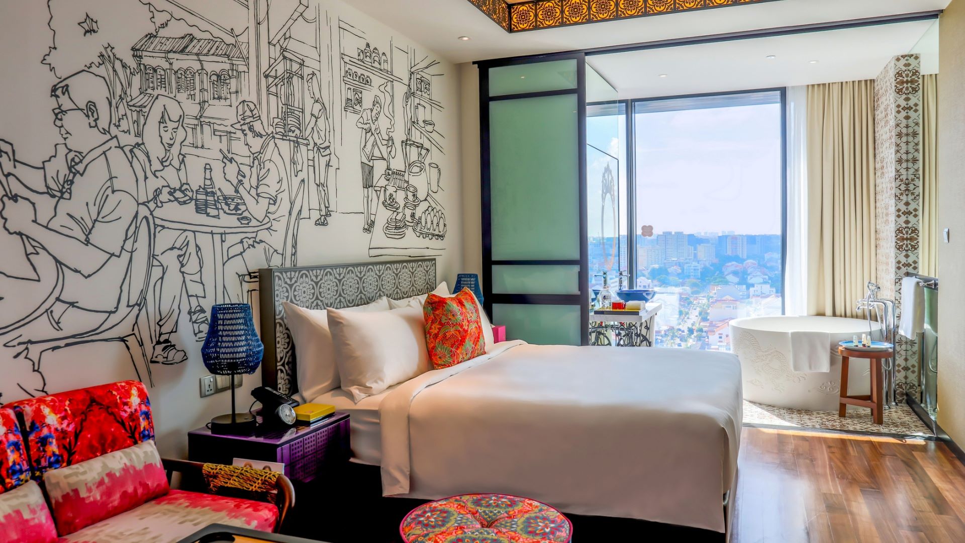 Contemporary hotel room showcasing a king bed, colorful decor, and artistic wall art, with a scenic view from the window.