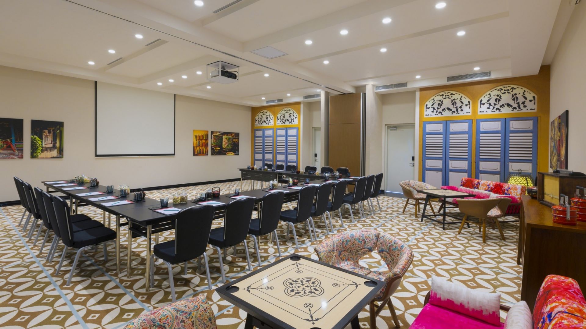 Decorative meeting room featuring a long table, colorful seating, and vibrant artwork on the walls.