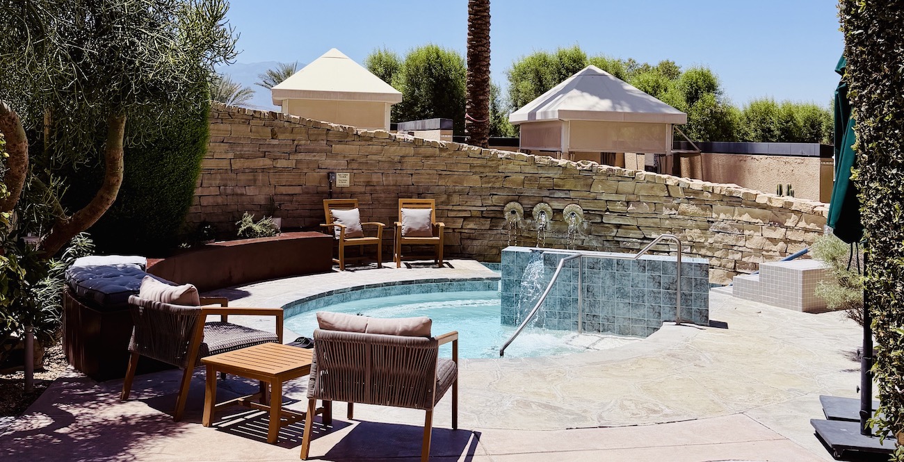 Relaxing plunge pool area with wooden chairs, soothing water features, and lush greenery at Renaissance Esmeralda Resort & Spa.