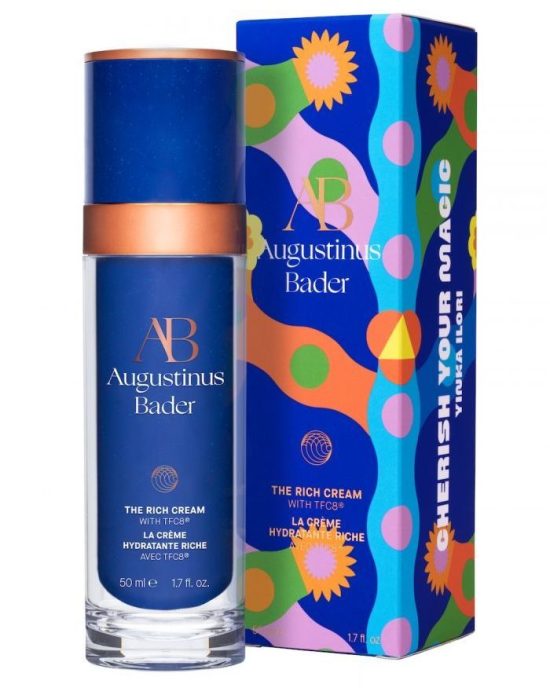Rich cream by Augustinus Bader in a blue bottle next to a colorful box with floral patterns and text.