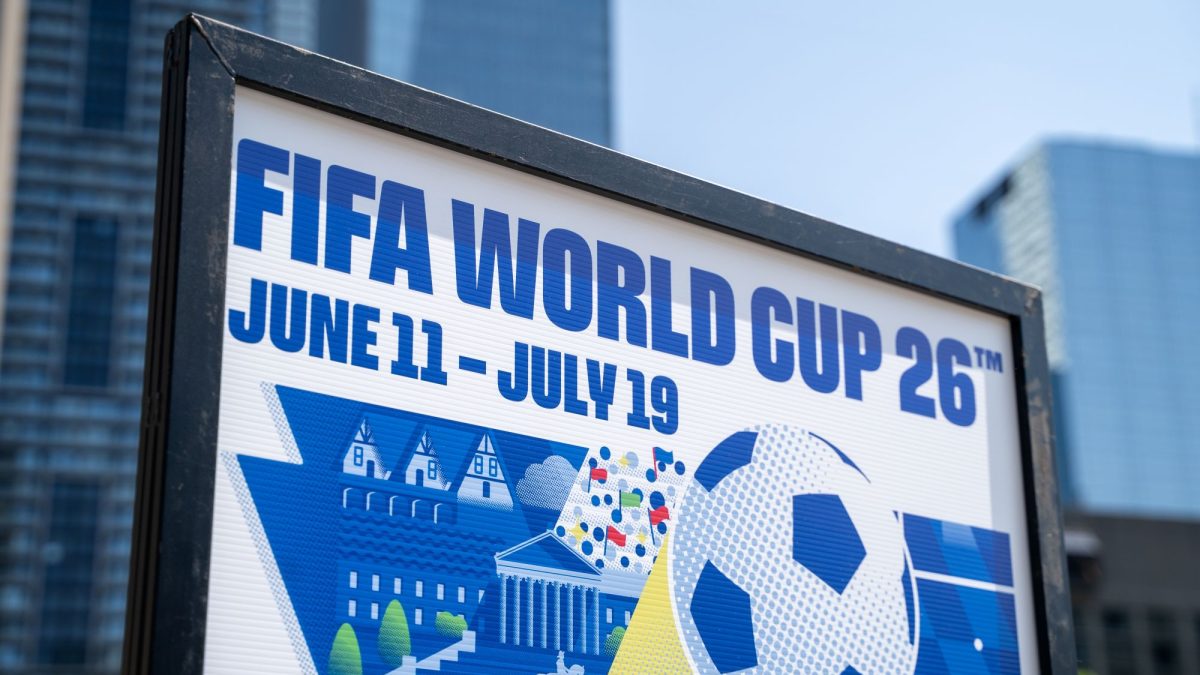 FIFA World Cup 2026 promotional sign displaying dates June 11 to July 19, with soccer ball and vibrant graphics.