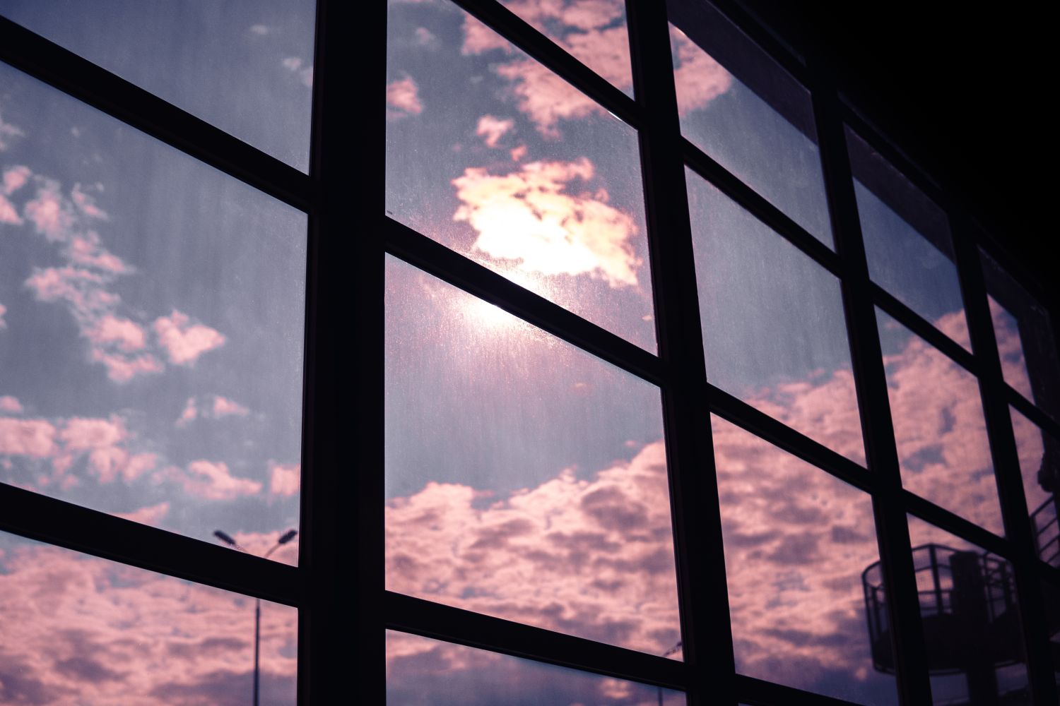 Window panes reflecting a colorful sky, illustrating the benefits of home window tinting for energy efficiency.