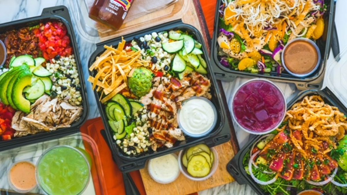 Colorful salad boxes featuring fresh vegetables, grilled chicken, and dressings, perfect for summer gatherings and celebrations.
