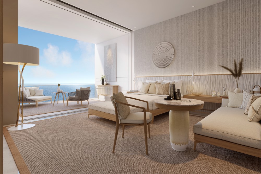Modern living area featuring light decor, comfortable seating, and large windows offering ocean views.