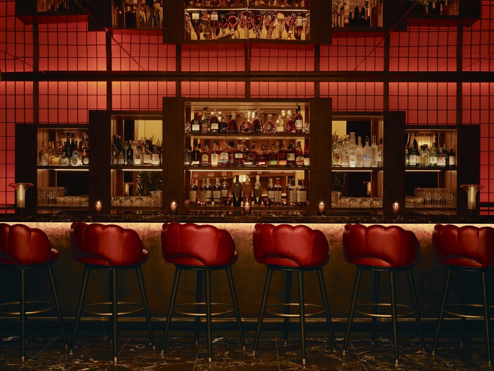Stylish bar area at Delano Miami Beach, featuring red decor, elegant seating, and a well-stocked selection of spirits.