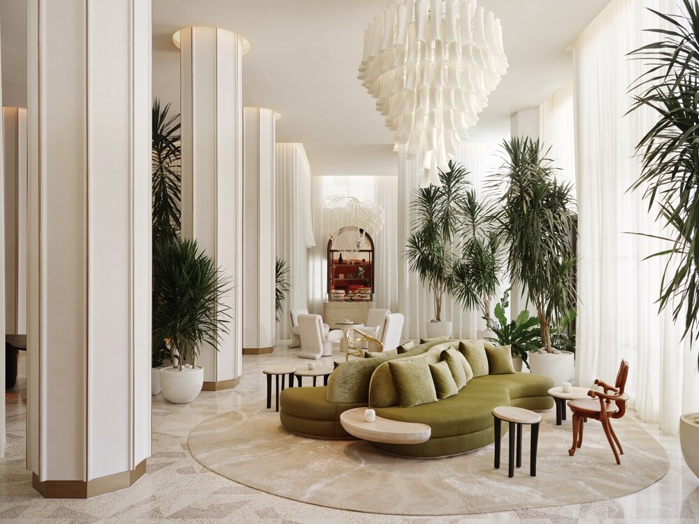 Stylish lobby at Delano Miami Beach featuring lush plants, elegant furniture, and a striking chandelier.