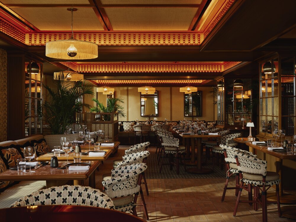 Elegant dining room at Delano Miami Beach featuring chic decor, warm lighting, and beautifully arranged tables.