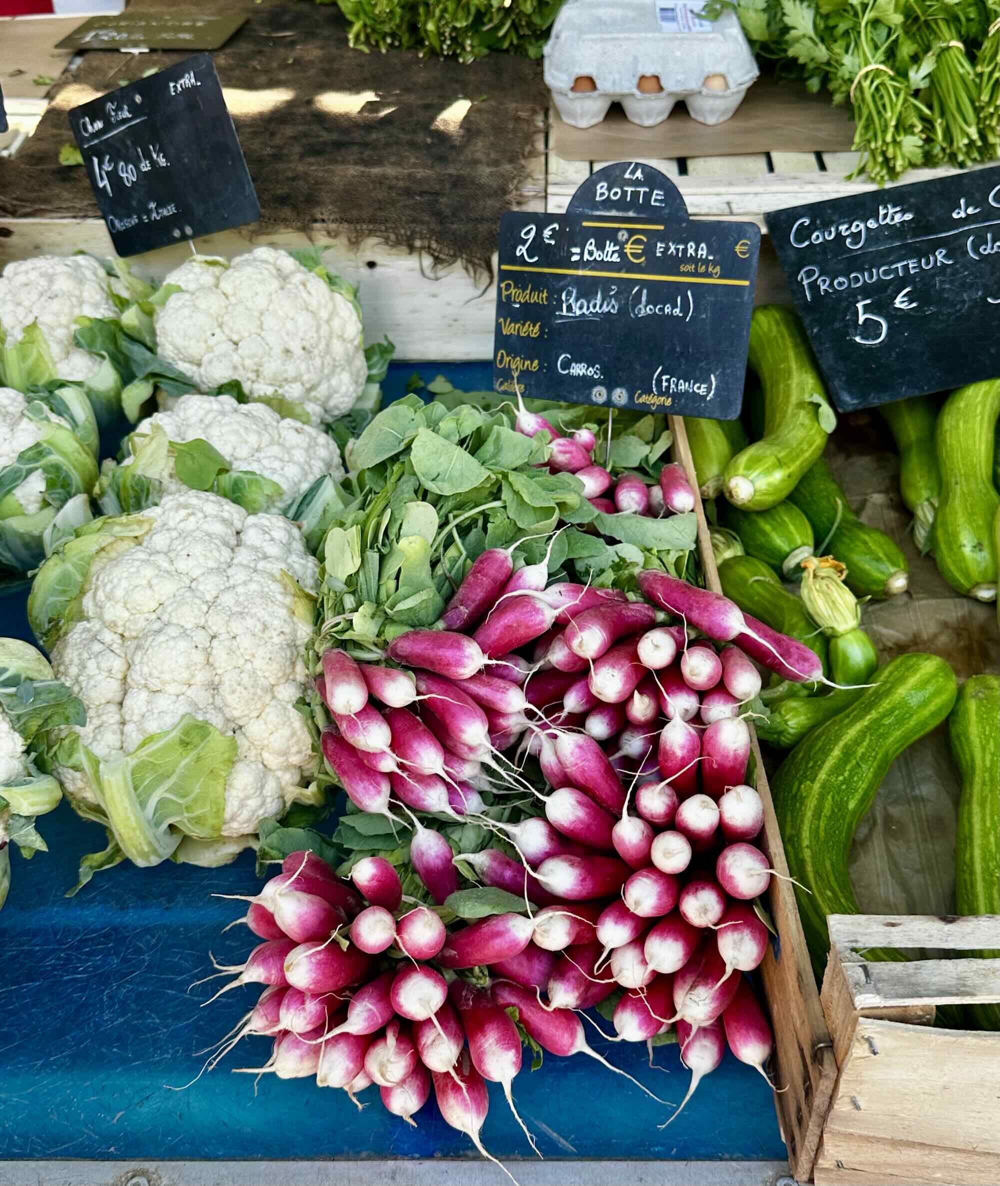 Fresh vegetables at Marché de la Libération, featuring cauliflower, radishes, and zucchini on display.