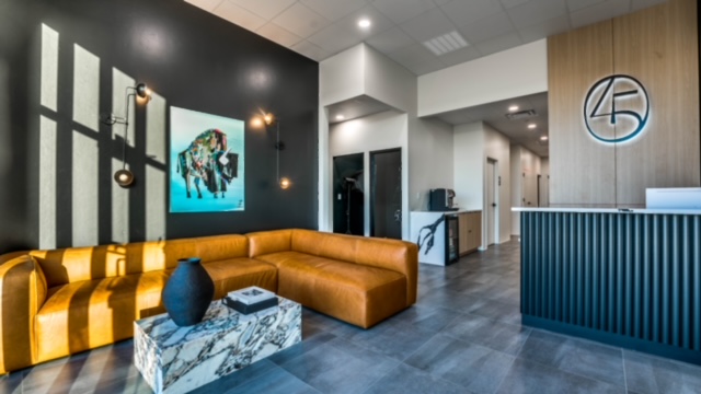Modern dental studio reception area featuring a cozy orange sofa, artwork, and sleek design elements.