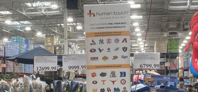 Human Touch massage chair display with pricing and details on brand partnerships at a Costco warehouse.