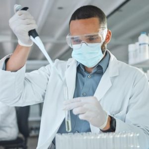 A lab technician using a pipette while analyzing samples, focused on peptide trends in a modern laboratory setting.