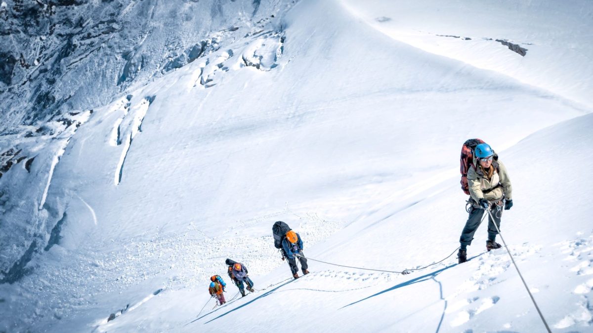 Climbers navigate a snowy slope while practicing sustainable mountaineering techniques to minimize their impact on the environment.