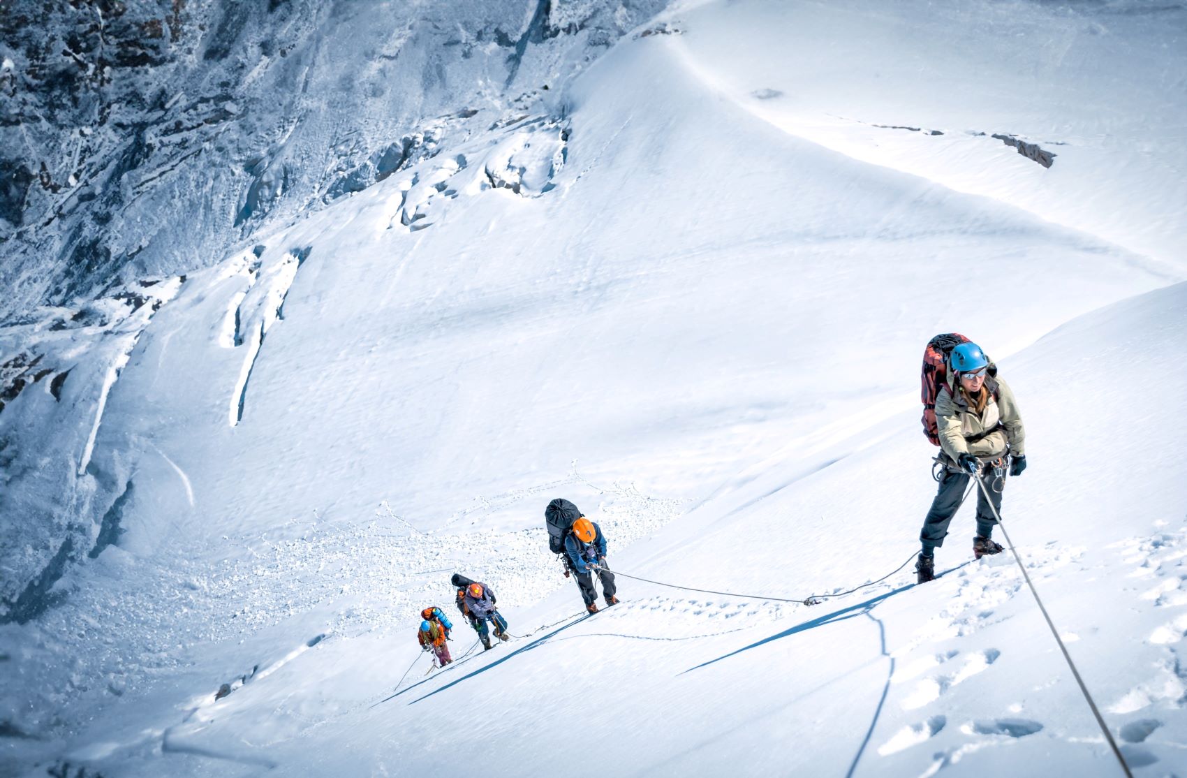 Climbers navigate a snowy slope while practicing sustainable mountaineering techniques to minimize their impact on the environment.