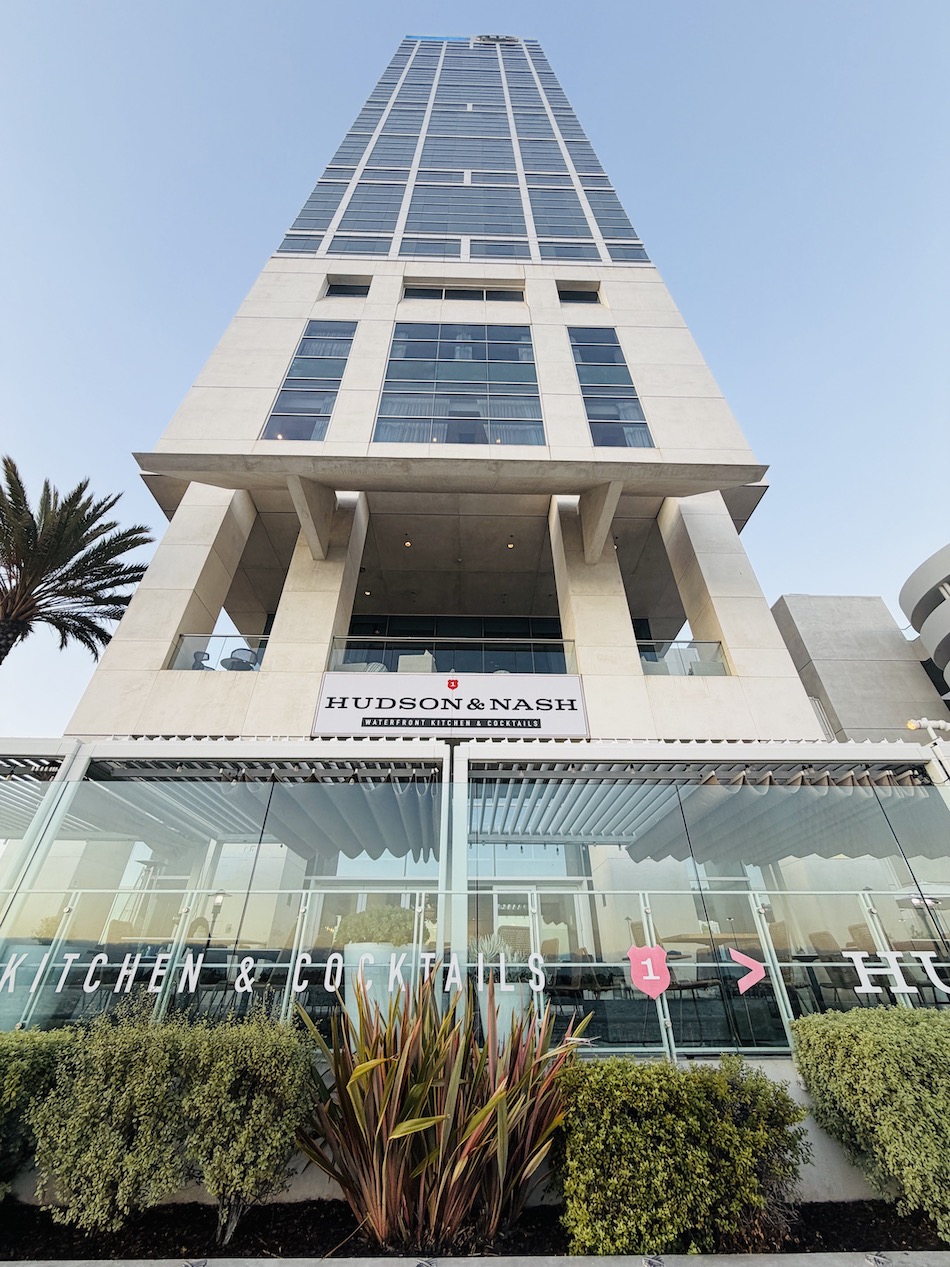 Hudson & Nash restaurant exterior showcasing modern architecture and palm trees in San Diego Bayfront.