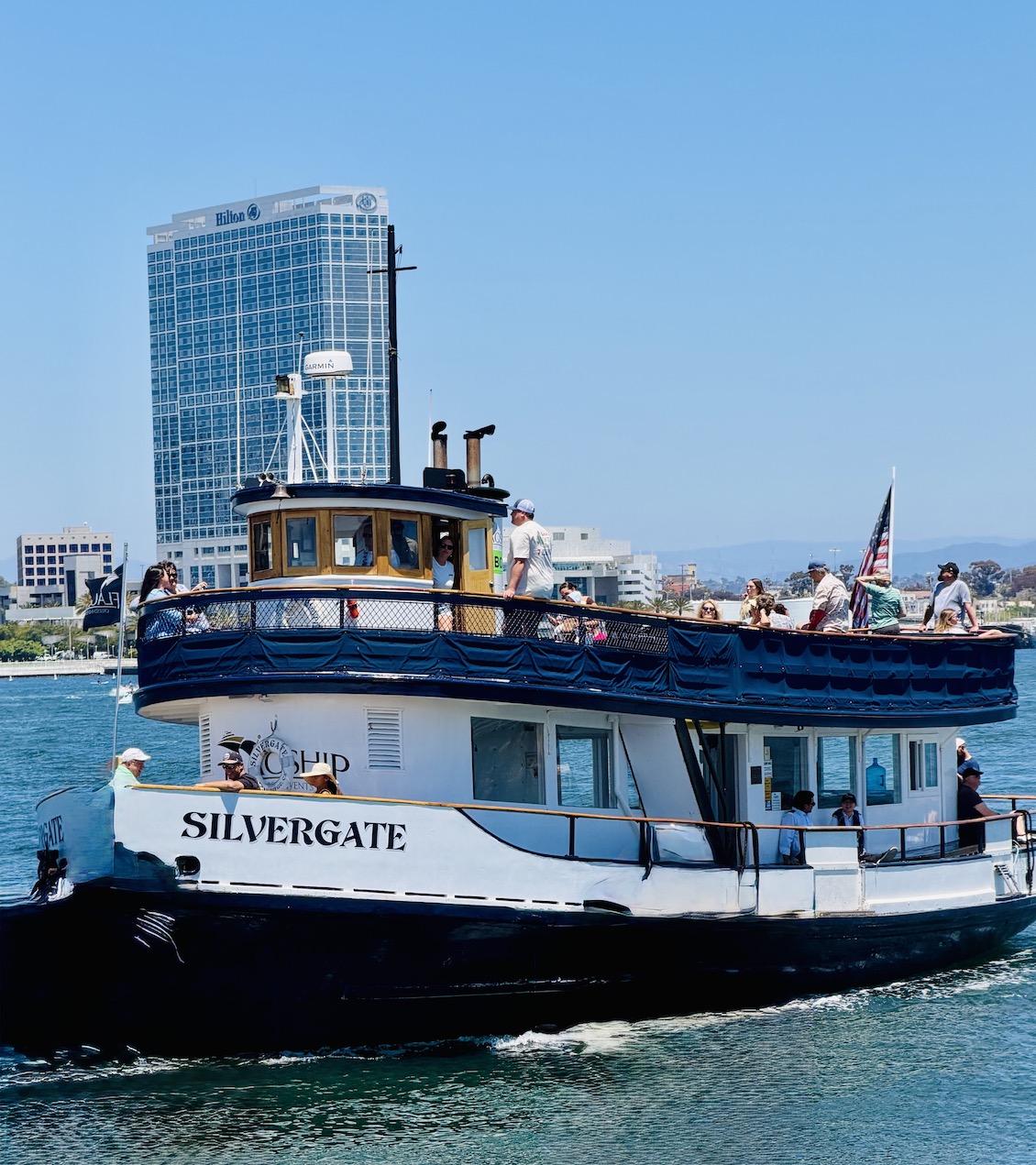 Ferry named Silvergate with passengers, navigating the bay, with the Hilton San Diego Bayfront in the background.