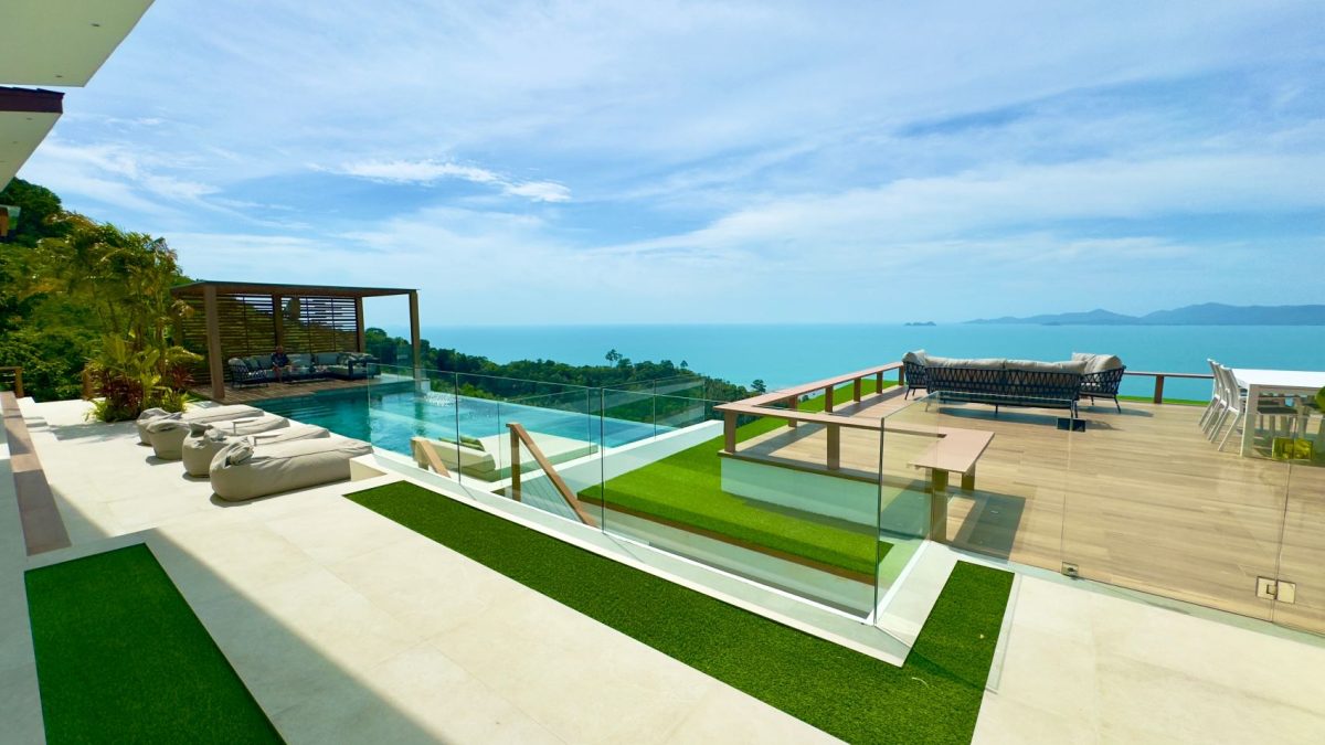 Luxurious villa with a pool and stunning ocean views, showcasing a stylish outdoor living space and surrounding greenery.