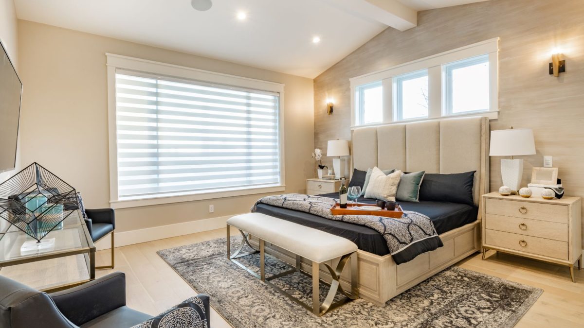 Modern luxury bedroom featuring natural light, layered textiles, a stylish bench, and elegant furnishings.