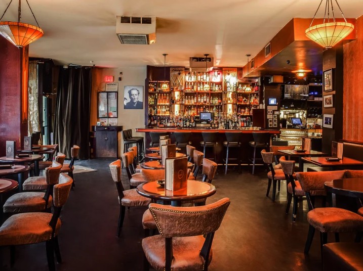 Luxurious cigar lounge featuring elegant furnishings, a well-stocked bar, and a welcoming atmosphere for premium cigar enthusiasts.