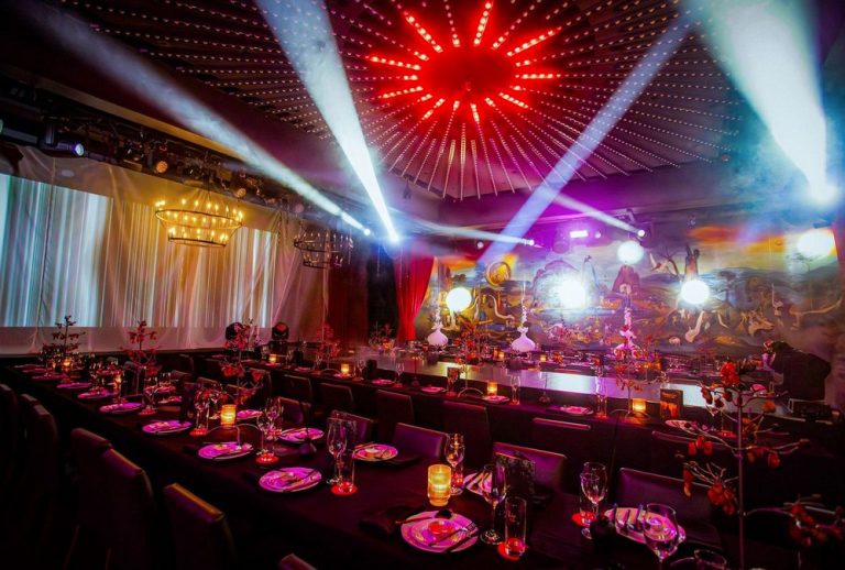 Luxuriously decorated dining area with ambient lighting and theatrical elements, ready for an immersive dining experience.