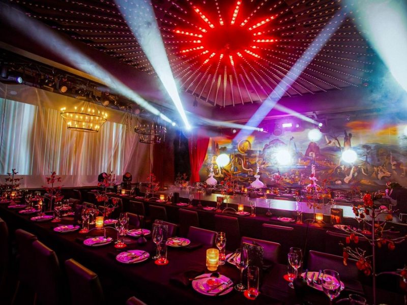 Luxuriously decorated dining area with ambient lighting and theatrical elements, ready for an immersive dining experience.