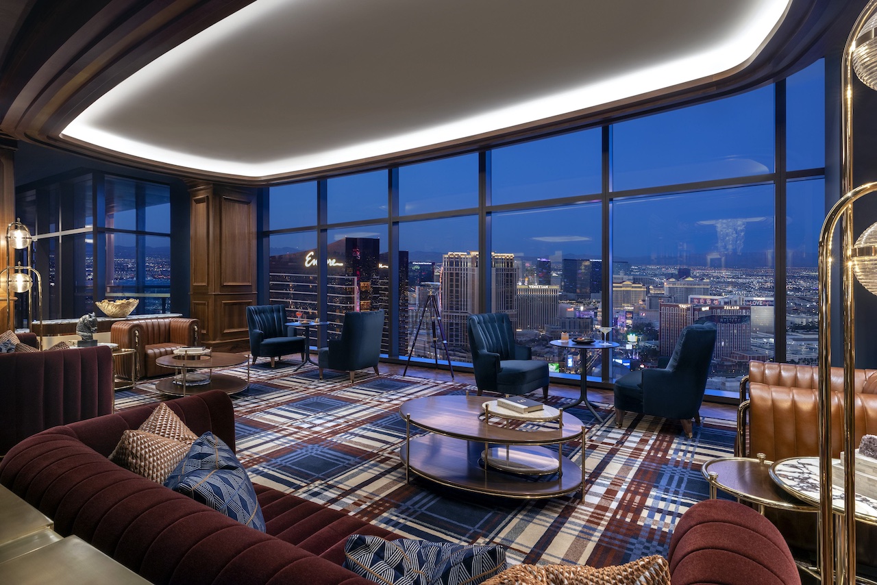 Luxurious lounge area at Conrad Complete in Las Vegas, featuring city views, plush seating, and modern decor.
