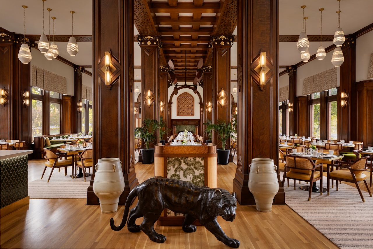 Bengal restaurant interior featuring dark wood accents, elegant lighting, and a tiger sculpture, showcasing a refined dining atmosphere.