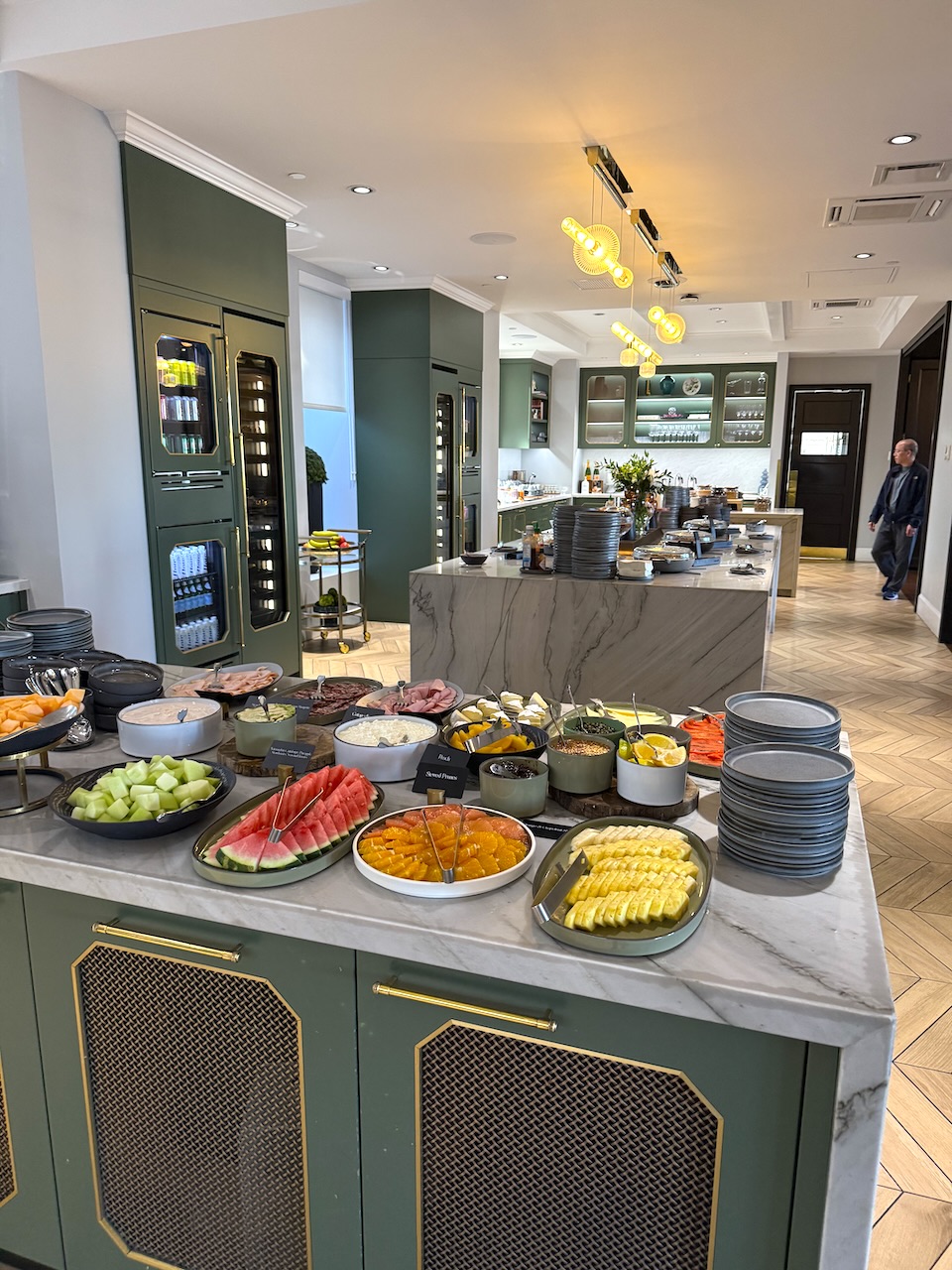 Buffet display featuring an assortment of fruits, cheeses, and meats in a stylish dining area at the Fairmont Empress hotel.