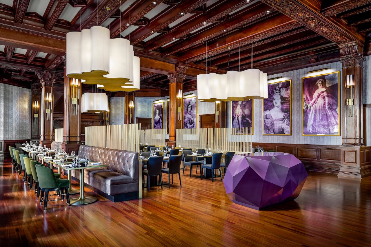 Elegant dining area at Fairmont Empress featuring plush seating, modern decor, and striking artwork on the walls.