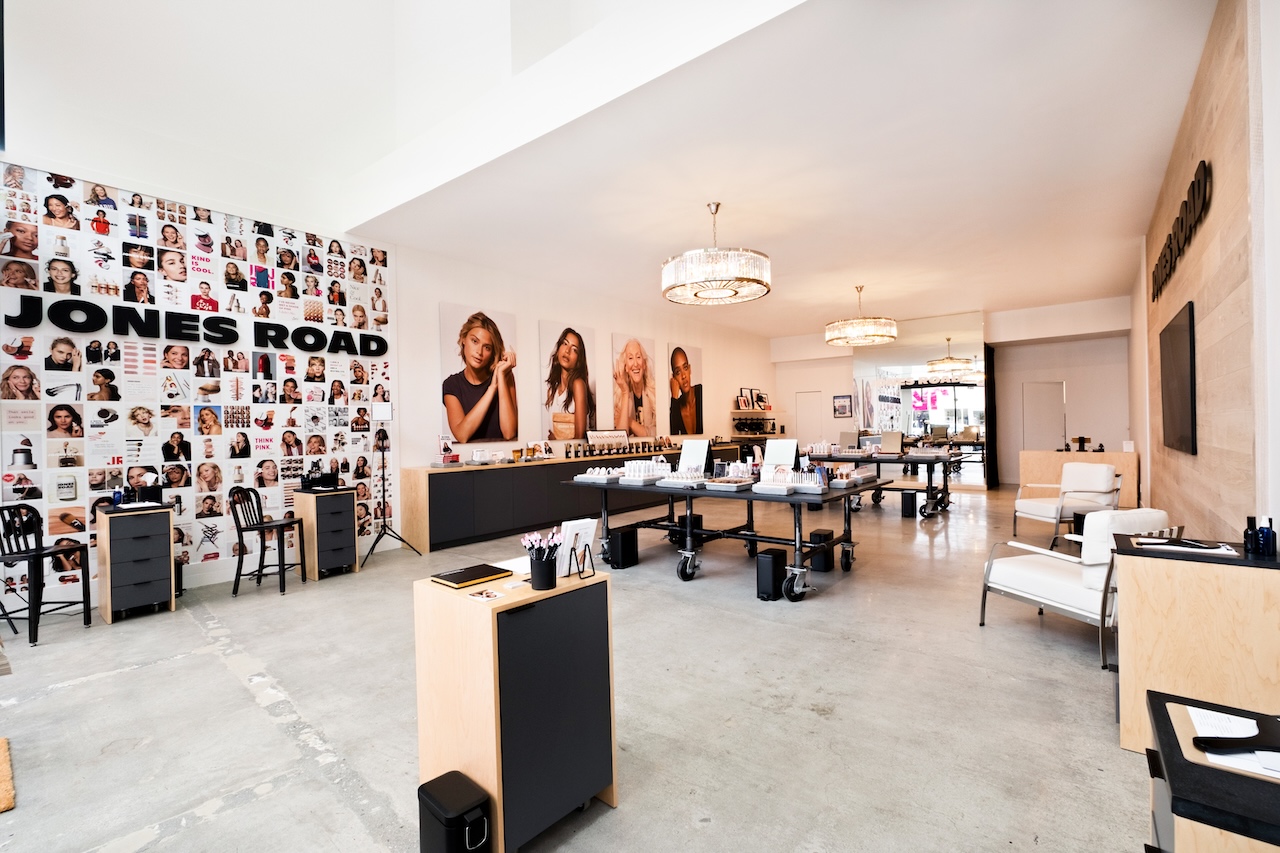 Interior view of the new Jones Road Beauty boutique in Santa Monica, featuring elegant displays and a vibrant photo wall.