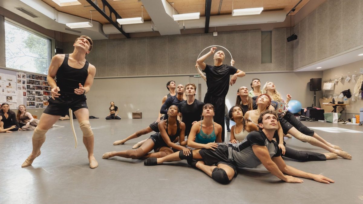 A diverse group of dancers rehearsing in a studio, showcasing dynamic poses and expressions during a performance.