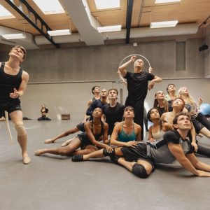 A diverse group of dancers rehearsing in a studio, showcasing dynamic poses and expressions during a performance.