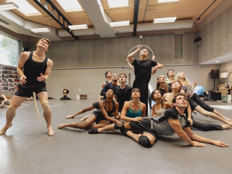 A diverse group of dancers rehearsing in a studio, showcasing dynamic poses and expressions during a performance.