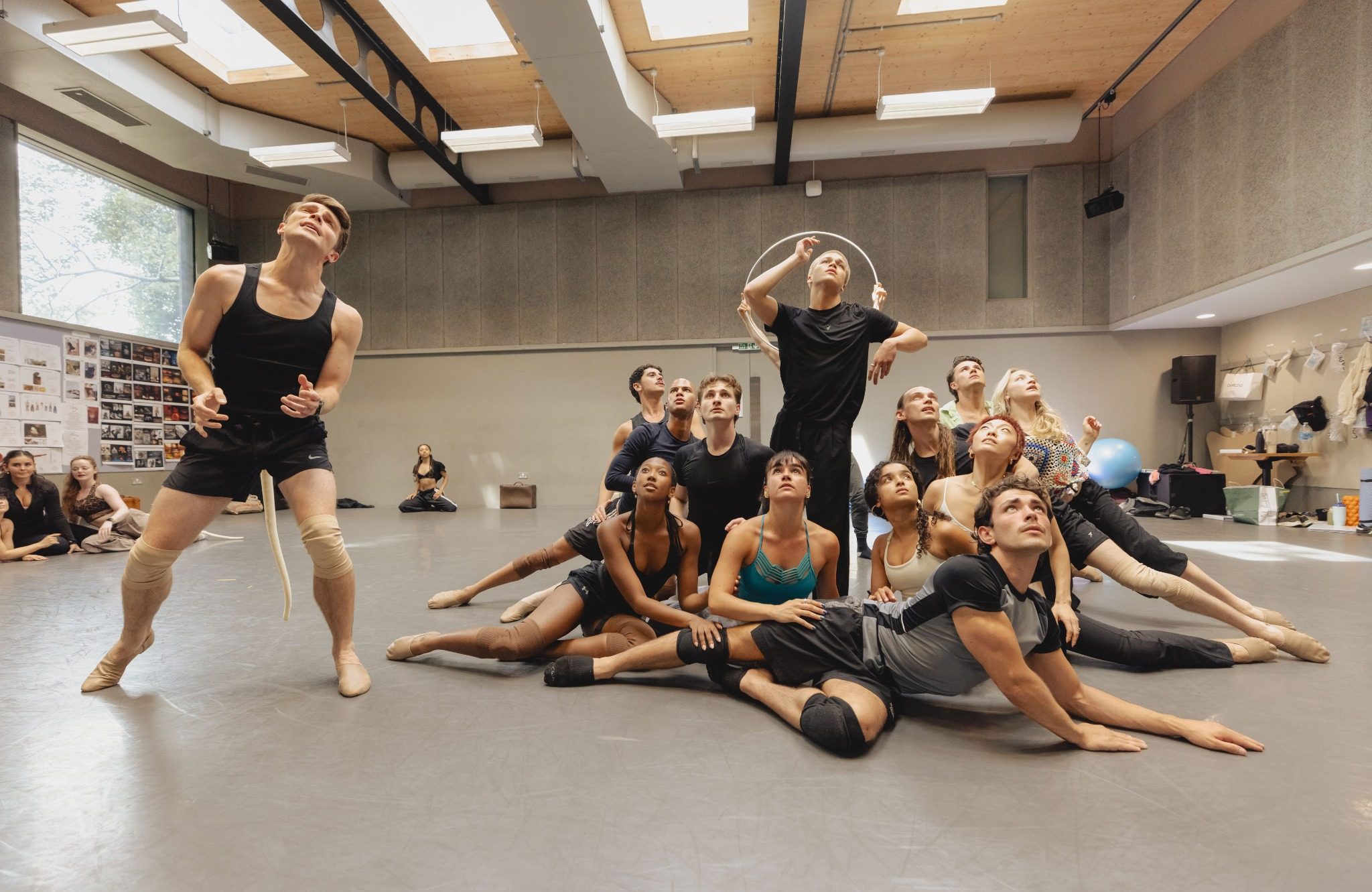 A diverse group of dancers rehearsing in a studio, showcasing dynamic poses and expressions during a performance.