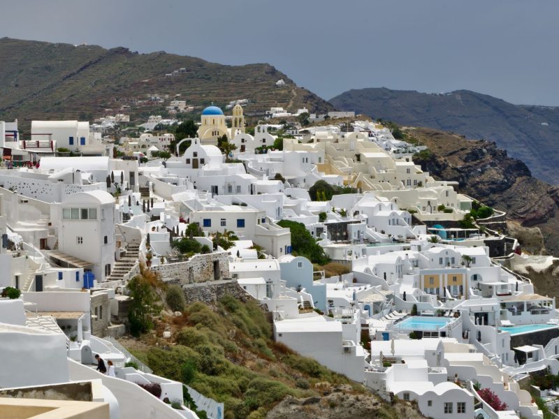 Whitewashed buildings with blue domes on a hillside, showcasing the charm of a lesser-known island destination.