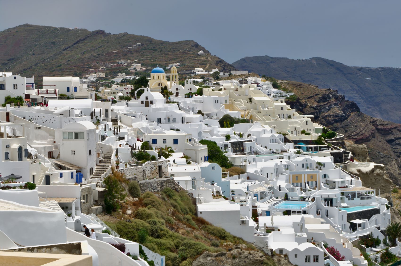 Whitewashed buildings with blue domes on a hillside, showcasing the charm of a lesser-known island destination.