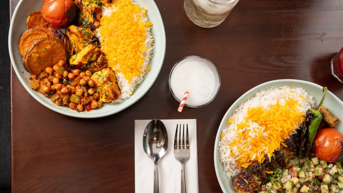 Vibrant Persian dishes featuring fluffy rice, grilled meats, roasted vegetables, and refreshing beverages on a wooden table.