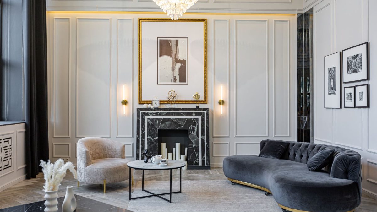 Luxurious living room featuring elegant furniture, a marble fireplace, and art decor against refined wall paneling.