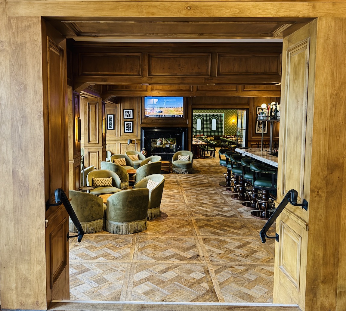View into a cozy, luxurious bar area with plush chairs and a fireplace at The Inn at Rancho Santa Fe.