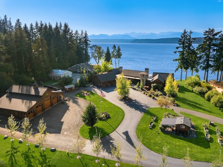Aerial view of a waterfront estate in the Pacific Northwest, showcasing lush greenery and scenic water views.